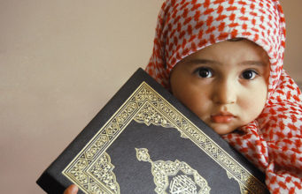 Mala muslimanka drzi Mushaf